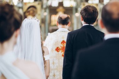 Rahip ve damat ve gelin kilisede kutsal evlilik sırasında ayakta. düğün töreni kavramı