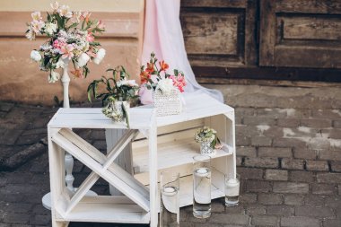 rustik düğün fotoğraf bölge. Beyaz kutu çiçek ve mum arka plan ahşap ahır kapıları kumaş ve shabby chic ile şık Düğün Fotoğraf standında. lüks arrangments