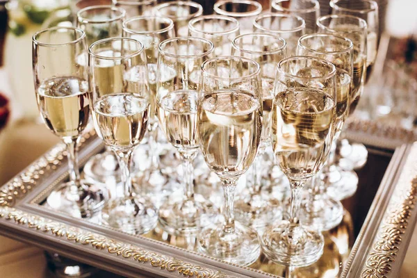 stylish golden glasses of champagne at luxury wedding reception. rich celebration. expensive catering at feast. new year and christmas celebrations and drinks