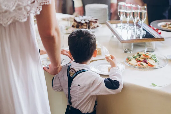 Malý Chlapec Jíst Potraviny Předkrmy Stole Svatební Hostinu Luxusní Catering — Stock fotografie