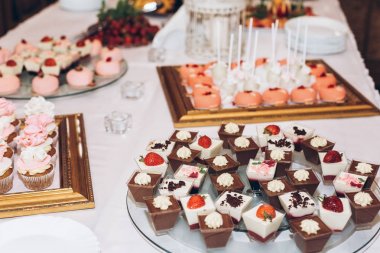 lezzetli şeker, tatlılar, kekler, çıkar dekore düğün Resepsiyon masaya çiçek ile. çikolata. kutlamalar olaylar ve duş için lezzetli pembe tatlılar. lüks şık catering