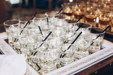 Düğün masa üzerinde siyah saman ile şık gözlük ile martini ya da jin. alkol bar. Kutlamalar ve etkinlikler için lezzetli içecekler. lüks şık catering