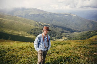 seyahat ve Yolculuk tutkusu kavramı. bulutlar içinde fotoğraf makinesi şık Gezgin adamla şapka ayakta dağlar üstüne. metin için yer. hipster adam seyahat. muhteşem atmosferik an.