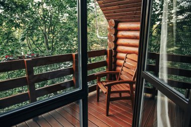 ahşap sandalye kabinin ağaçların arasında verandada. Cottage ormanda ve dağ manzaralı balkon. Atmosferik an. yaz tatili. kırsal ülke dinlenmek zaman