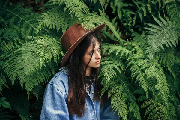 Κομψό Hipster Κορίτσι Στο Καπέλο Που Κάθεται Θάμνους Φτέρη Ανάμεσα — Φωτογραφία Αρχείου