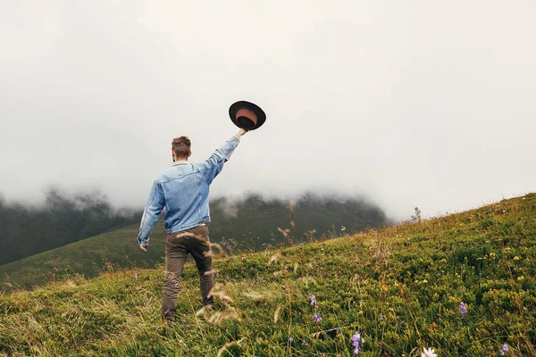 Homem Viajante Elegante Segurando Chapéu Andando Topo Montanhas Ensolaradas Nas — Fotografia de Stock
