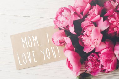 Anne, zanaat kartındaki metin ve pembe peonies buket ışık beyaz rustik ahşap zemin üzerinde seviyorum. çiçek tebrik kartı kavramı, düz yatıyordu. mutlu anneler günü. ihale görüntü