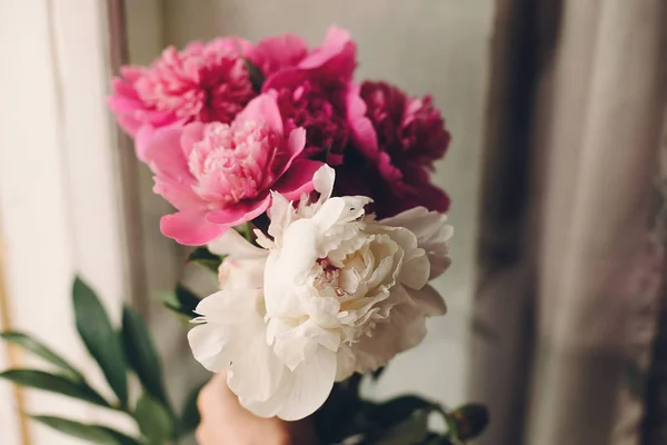 素朴な木製白地に花の花束を持っている手の上から見る — ストック写真