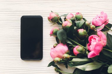 çok güzel pembe peonies ve telefon ile boş perde rustik Beyaz ahşap arka planda Üstten Görünüm