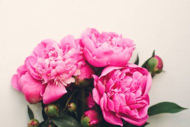 çok güzel pembe peonies buket çiçek tebrik kartı için beyaz rustik ahşap zemin üzerinde. 