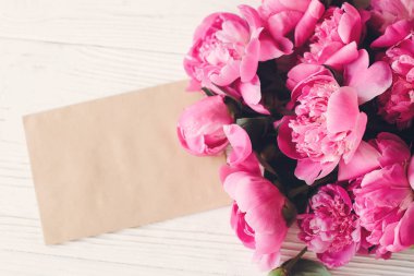romantik pembe peonies buket rustik Beyaz ahşap arka plan üzerinde boş tekne kart ile
