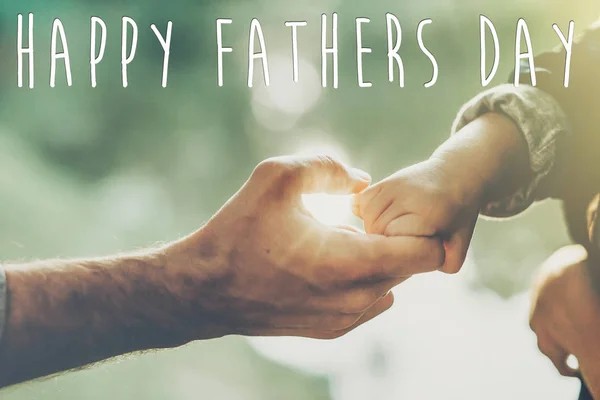 幸せな父の日のテキスト グリーティング カードの概念 父と幼い息子の夏の森で日光の下で手を繋いで — ストック写真