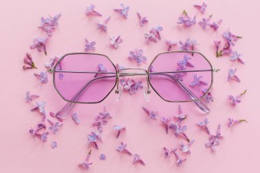Eflatun çiçekli pembe arka plan üzerinde şık mor boho güneş gözlüğü. yaratıcı trendy düz metin için yer yatırın. Modern moda görüntü. yaz tatil ve Festivali kavramı