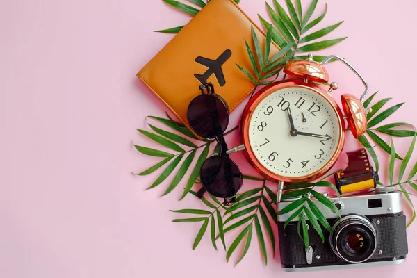 护照与飞机 太阳镜 相片照相机 时钟与绿色棕榈叶子在粉红色背景 夏天平躺 暑假概念 旅行概念和流浪的时间 — 图库照片