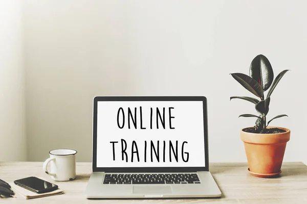 çevrimiçi eğitim metni ahşap Masaüstü telefon, defter, kahve ve bitki ile dizüstü bilgisayar ekranında. iş çalışma alanı. İnternet Eğitim kavramı. e-öğrenme