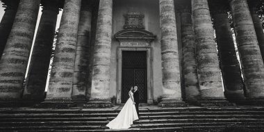 Güzel parktaki eski şatonun yakınlarında güneş ışığında poz veren muhteşem bir düğün çifti. Tarz sahibi güzel gelin ve damat el ele tutuşuyorlar.