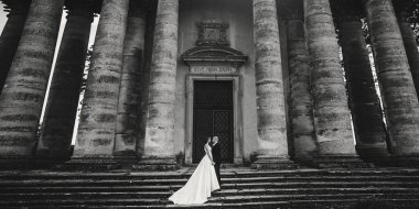 Güzel parktaki eski şatonun yakınlarında güneş ışığında poz veren muhteşem bir düğün çifti. Tarz sahibi güzel gelin ve damat el ele tutuşuyorlar.