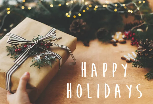 Happy Holidays napis tekst na stylowy rustykalny prezent świąteczny, sosna — Zdjęcie stockowe