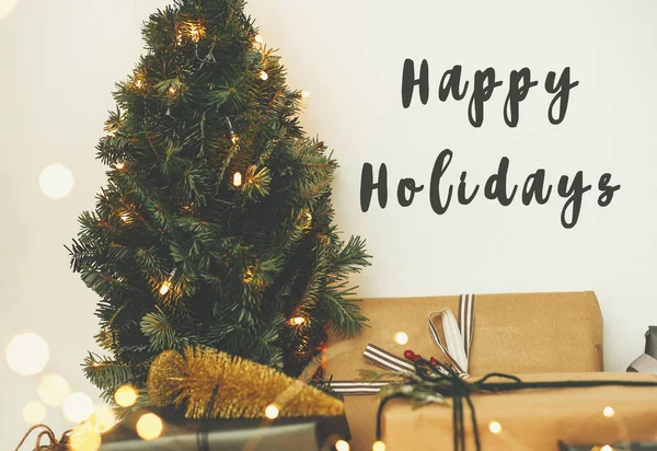Happy Holidays tekst teken op kerstboom in gouden lampjes boke — Stockfoto