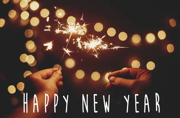幸せな新年のテキストサイン上の輝く輝きで手でバックグロ — ストック写真