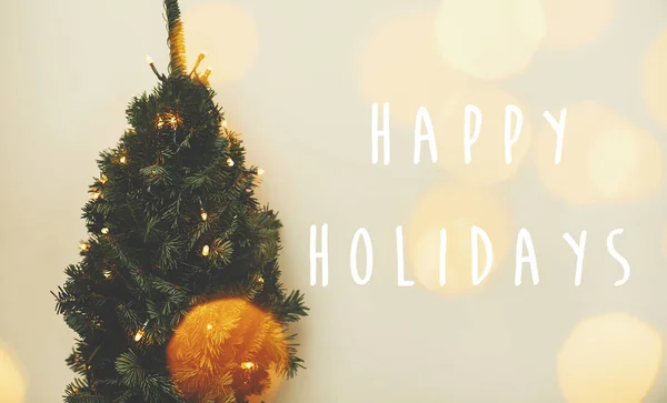 ハッピーホリデーテキストサインオンクリスマスツリーと黄金のライトbok — ストック写真