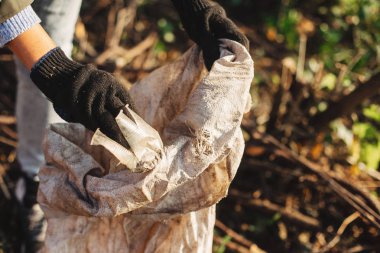 Gönüllü, parkta kirli plastik bardakları topluyor. Kadın teslim oldu.