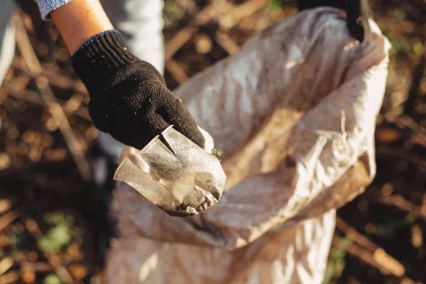 Freiwillige sammeln im Park schmutzige Plastikbecher auf. Frau Hand in Hand — Stockfoto