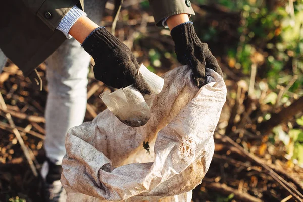 Volontaire ramasser des gobelets en plastique sale dans le parc. Femme main en g — Photo