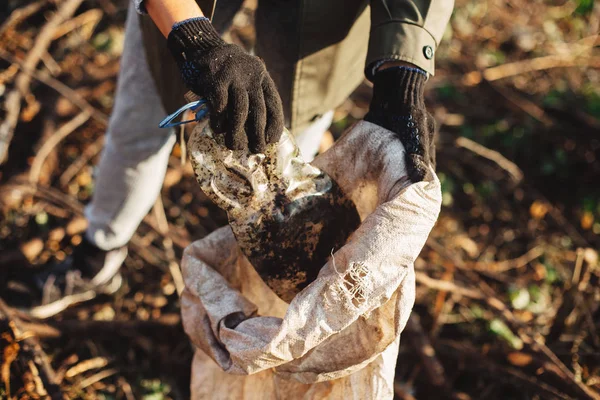 Parkta kirli plastik şişeleri toplayan bir gönüllü. Kadın eli! — Stok fotoğraf