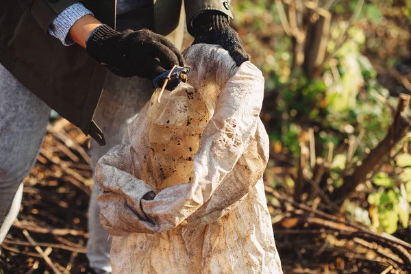 Umweltaktivist sammelt schmutzige Plastikflaschen im Park auf. Frau ha — Stockfoto