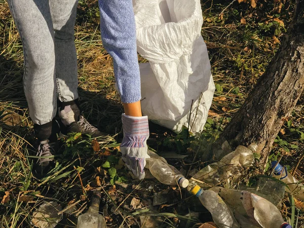 Parkta kirli plastik şişeleri toplayan bir gönüllü. Kadın eli! — Stok fotoğraf