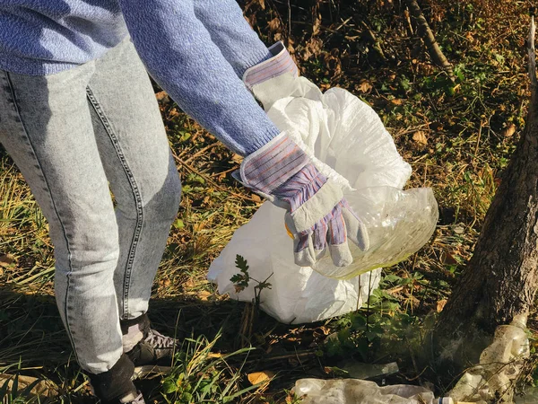 Parkta kirli plastik şişeleri toplayan bir gönüllü. Kadın eli! — Stok fotoğraf