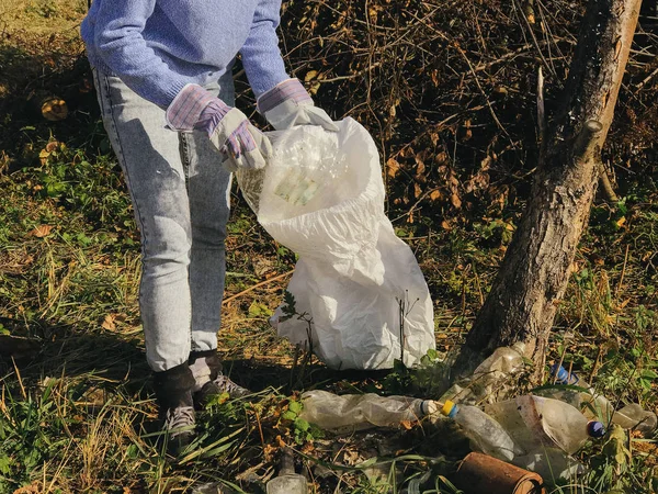 Parkta kirli plastik şişeleri toplayan bir gönüllü. Kadın eli! — Stok fotoğraf