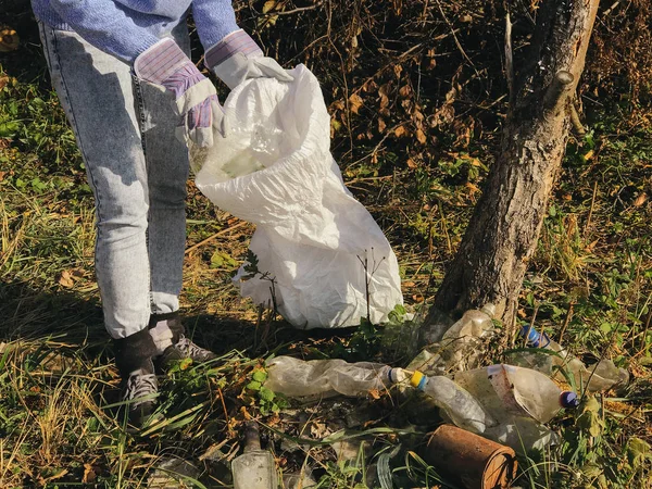 Freiwillige sammeln im Park schmutzige Plastikflaschen auf. Frau Hand i — Stockfoto