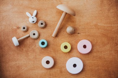 Çocuk için çevre dostu, plastik ücretsiz eğitim oyuncakları. Tahta masadaki çocuk için şık tahta oyuncaklar. Parçalanmış halkaları ve basit tavşanı olan modern renkli ahşap piramit..