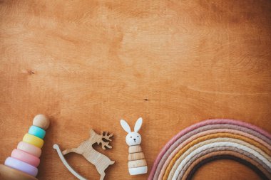 Tahta masadaki çocuk için şık ahşap oyuncaklar, fotokopi alanı olan düz yataklar. Yüzüklü ve basit tavşanlı modern renkli ahşap piramit. Bebek için çevre dostu plastik oyuncaklar