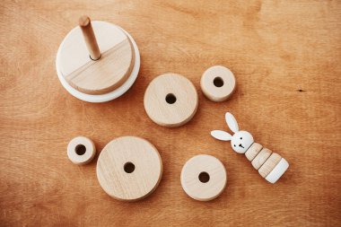 Çocuk için çevre dostu, plastik ücretsiz eğitim oyuncakları. Tahta masadaki çocuk için şık tahta oyuncaklar. Parçalanmış halkaları ve tavşanı olan modern basit ahşap piramit..