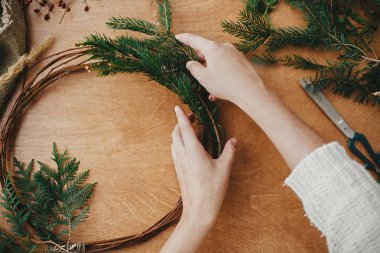 Eller köknar dalları ve kozalak, iplik, makas tutuyordu.