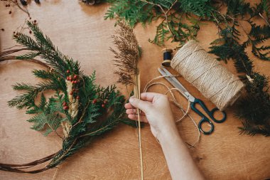 Kırsal Noel çelengi yapıyorum. Ellerinde ot, dut, köknar