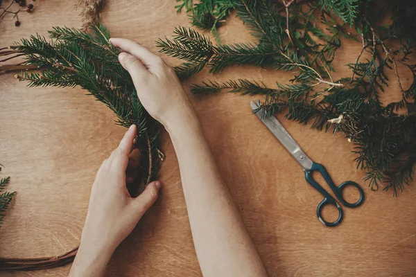Eller köknar dalları ve kozalak, iplik, makas tutuyordu.