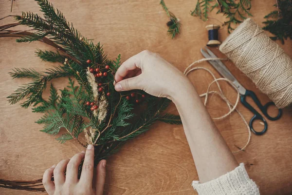 Christmas wreath workshop. Hands holding fir branches, pine cone — Stock Photo, Image