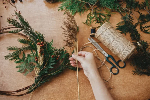 Kırsal Noel çelengi yapıyorum. Ellerinde ot, dut, köknar