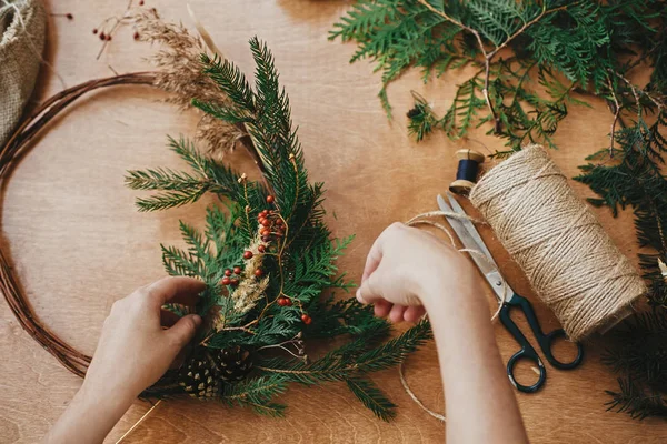 Mãos segurando ramos de abeto e cones de pinheiro, bagas, fio, scis — Fotografia de Stock