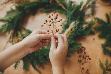 Kırsal Noel çelengi yapıyorum. Elleri böğürtlen ve köknar tutan