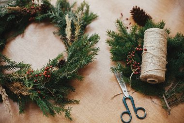 Kırsal Noel çelengi. Firavun dalları, kozalaklar, iplik, berri