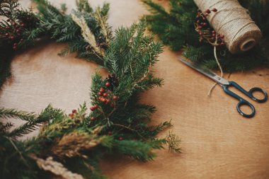 Kırsal Noel çelengi. Firavun dalları, kozalaklar, iplik, berri