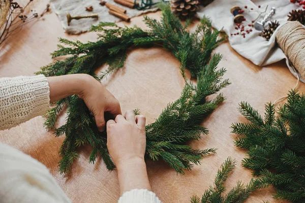 Machen rustikalen Weihnachtskranz. Hände, die Tannenzweige halten und — Stockfoto