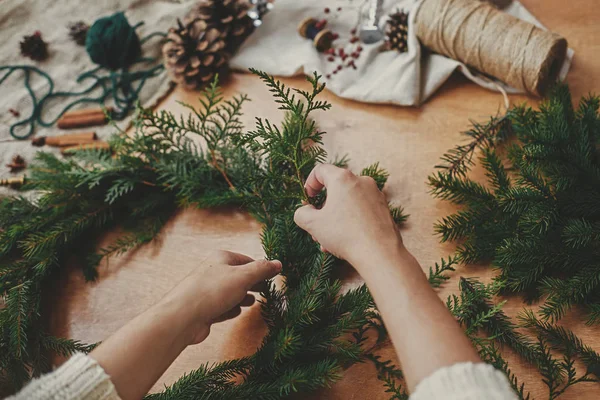 Hands holding fir branches, and pine cones, thread, berries, sci — Stock Photo, Image