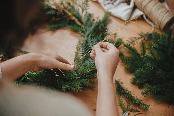 Hands holdingherbs and  fir branches, pine cones, thread, berrie — Stock Photo, Image