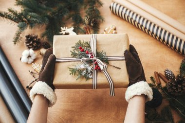 Mutlu noeller. Şık eldivenler giymiş eller kırsal bir Noel yaşatıyor.